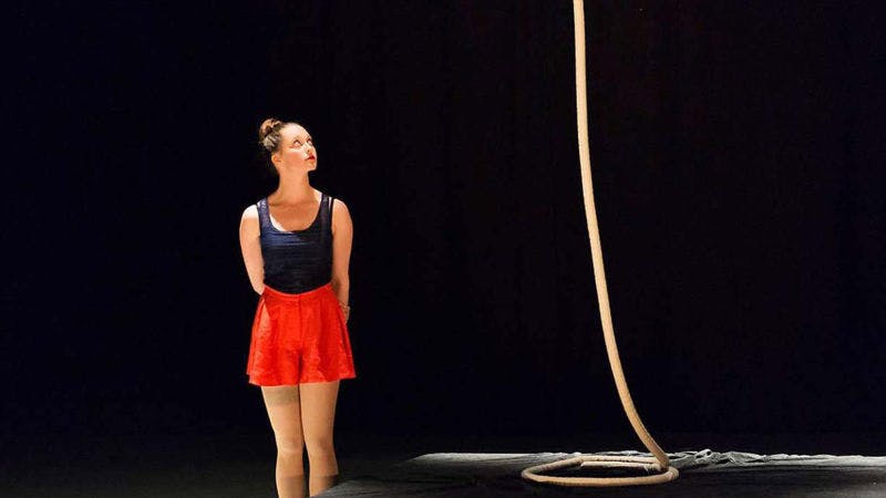 Melinda, stood next to her rope whilst performing on stage. Looking up at it, longingly.