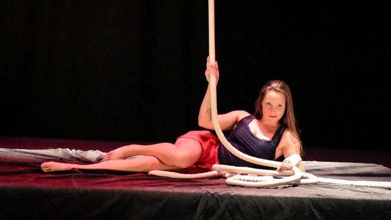 Melinda draped across a crash mat, caressing her aerial rope